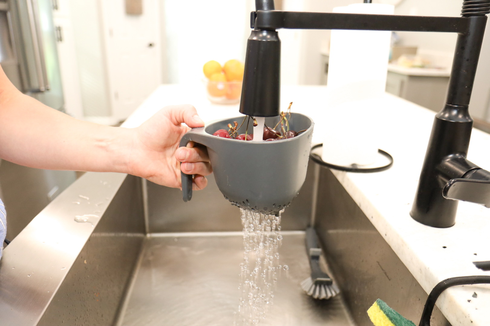 Mom rinsing berries under the sink, healthy lifestyle